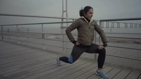 Lächelnde-Sportlerin,-Die-Vor-Dem-Training-Die-Beine-Streckt