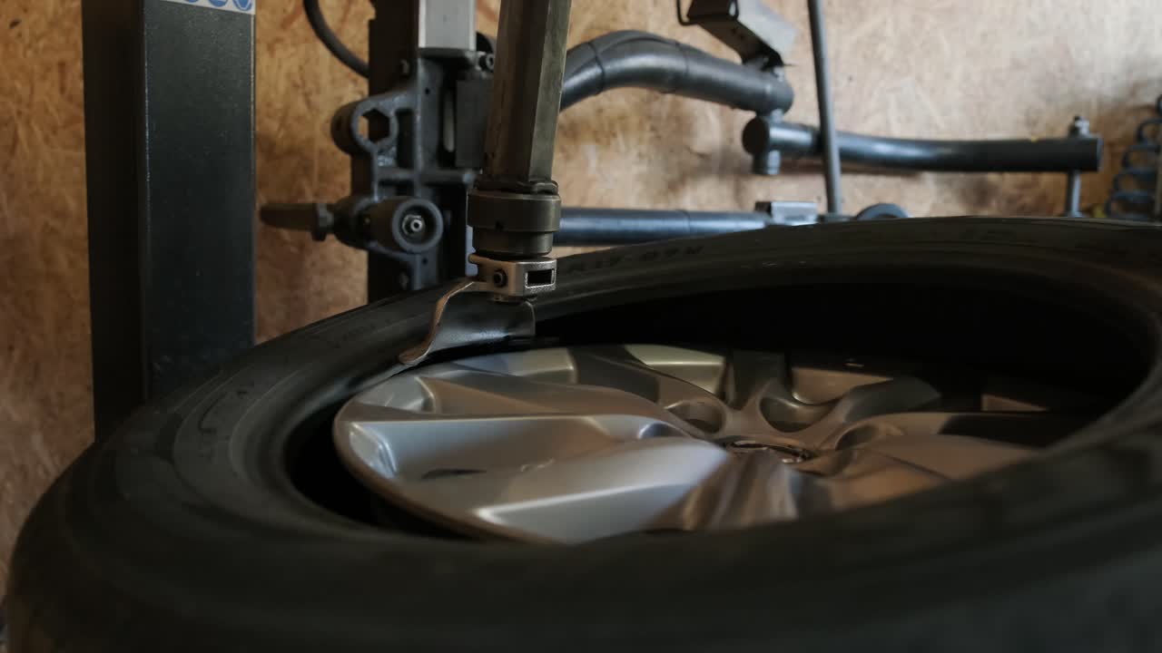 cambiar un neumático, un mecánico de automóviles está cambiando un neumático en un garaje