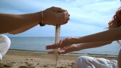 arena vertiendo en las manos humanas en la playa. concepto de relajación