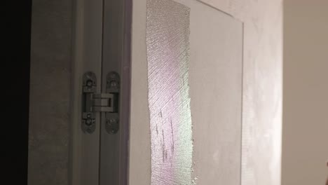 worker applies decorative plaster with a thin spatula. giving a unique texture to white walls. venetian plaster