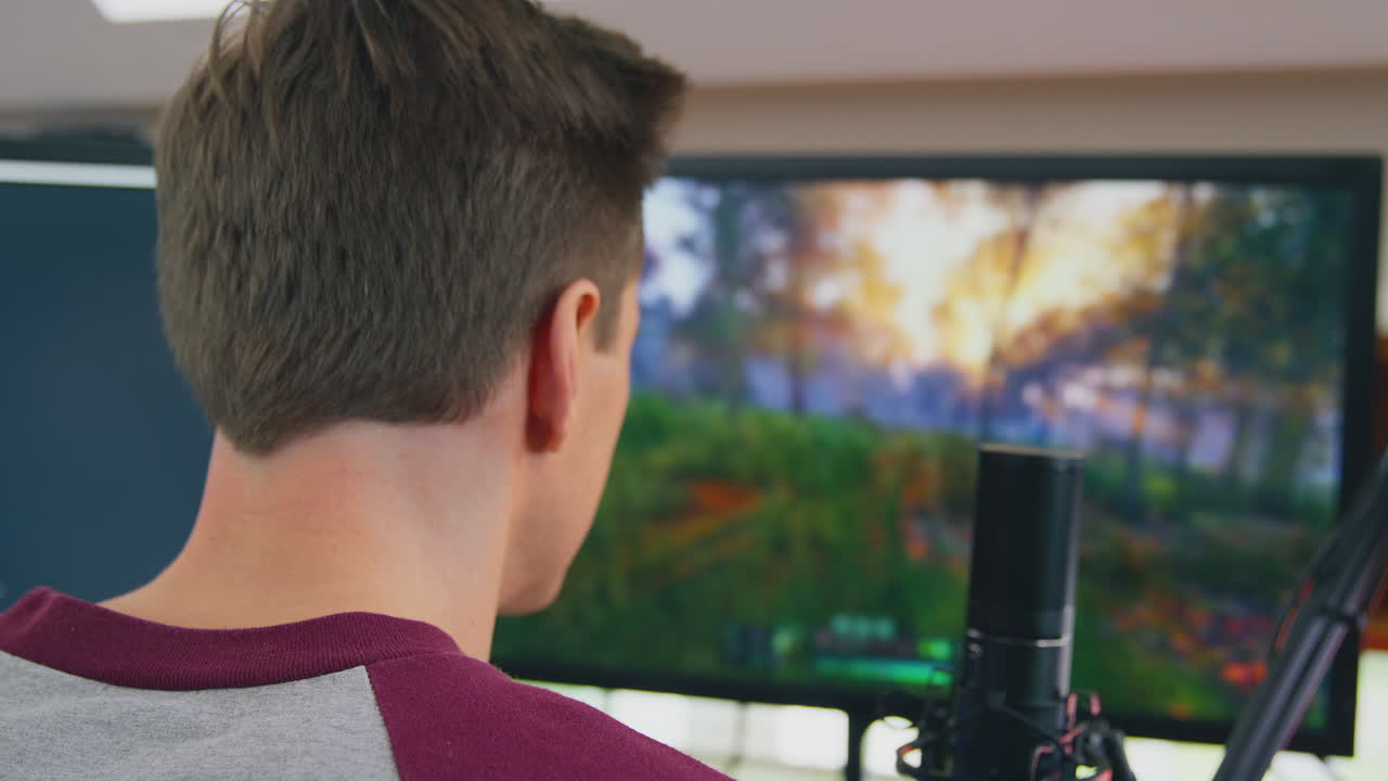 Homem jogando em casa, sentado à mesa, transmitindo ao vivo um jogo de tiro em vários monitores
