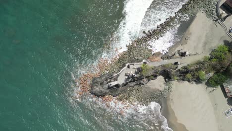 aerial of batu bolong temple, also known as pura batu bolong, an beautiful and sacred sea temple located on the southwestern coast of bali, indonesia