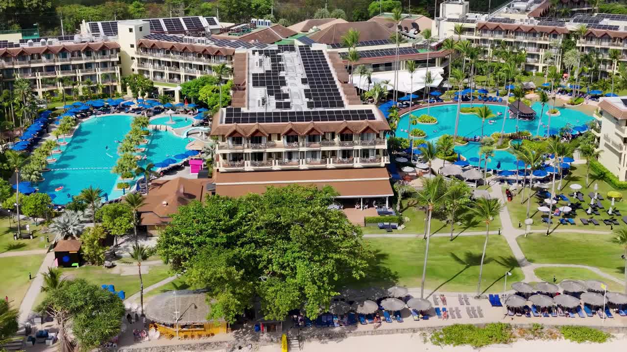 Drone footage highlighting vibrant pools and lush gardens at a resort, showcasing leisure and relaxation.