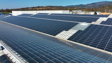 aerial view of blue photovoltaic solar panels mounted on industrial building roof for producing green ecological electricity. production of sustainable energy concept