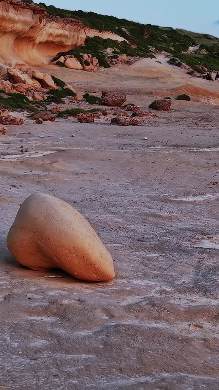 Vista del tramonto sulla spiaggia rocciosa lungo la costa di Malta con scogliere