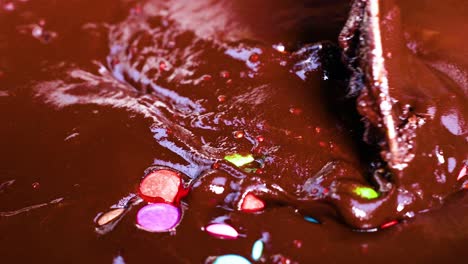 colorful candies stirred into rich chocolate mixture