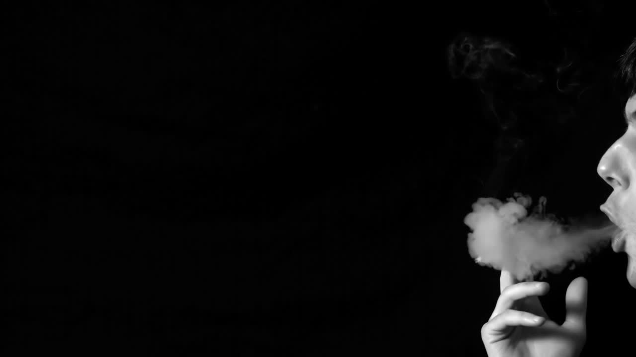 담배 연기를 불어넣는 남자