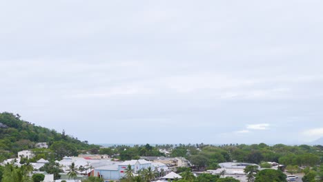 aerial view of port douglas, showcasing lush greenery, coastal landscape, and overcast skies, captured in a smooth panning motion