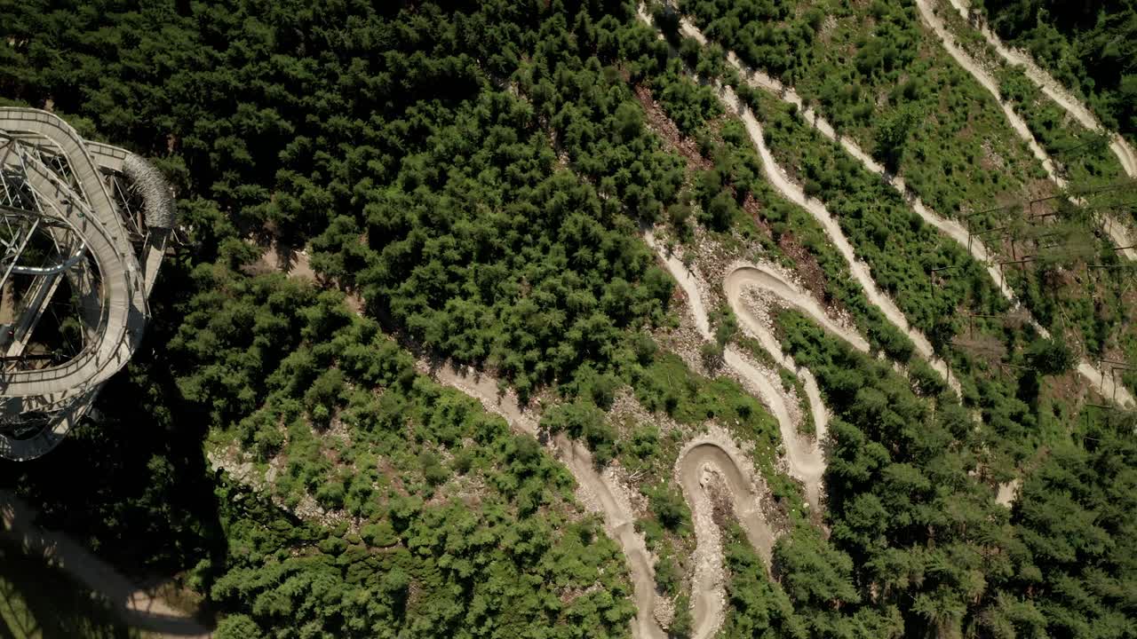 zoom aéreo en el punto de vista de un dron de una atracción de la torre sky walk y un sendero para bicicletas mtb cercano en las montañas de dolni morava, república checa