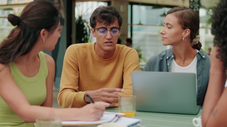 Close up of a diverse group of students having a lively conversation and using
