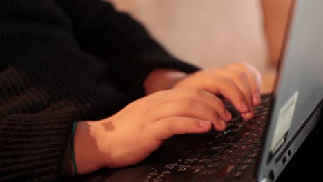 teenager's hands typing on a laptop