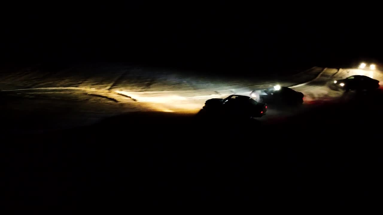 Winter drift competition on snowy racetrack during night, led light illuminate