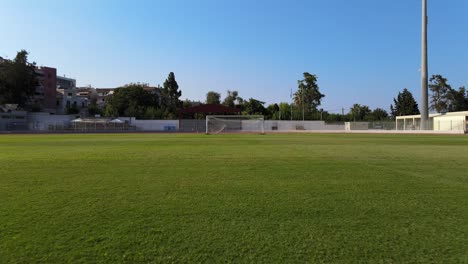 Eine-POV-Ansicht-Einer-Drohne-Auf-Einem-Fußballfeld,-Die-Von-Der-Spielfeldmitte-Zum-Torpfosten-Sprintet