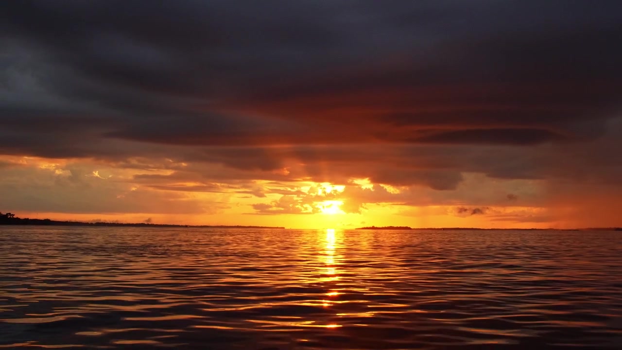 Auringonnousu Amazonjoella, nähtynä veneestä matkalla kohti Parintinsia, Brasiliaa.