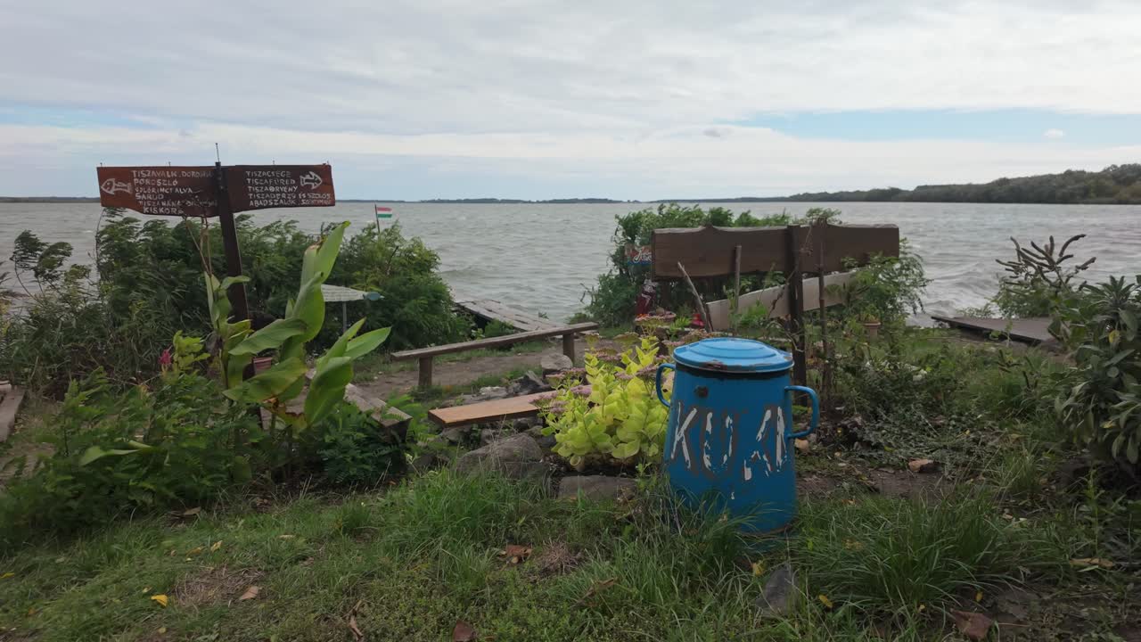 Flowery garden with the view of Lake Tisza on a windy day at the Jóreménység-sziget community place in Abádszalók, Hungary