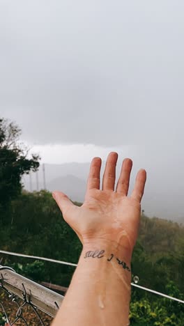 Hand in the Rain with Inspirational Tattoo