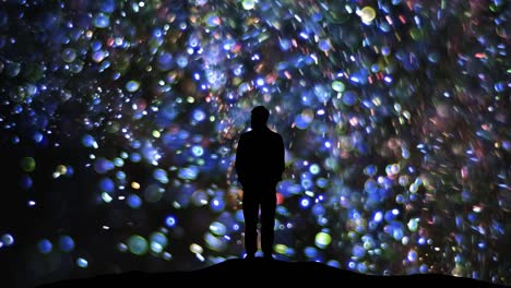 the man standing on a blue shimmering particles background