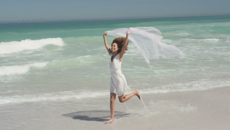 african american woman playing with the wind at beach