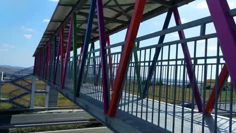 Cars-driving-on-highway-under-an-iron-colored-bridge