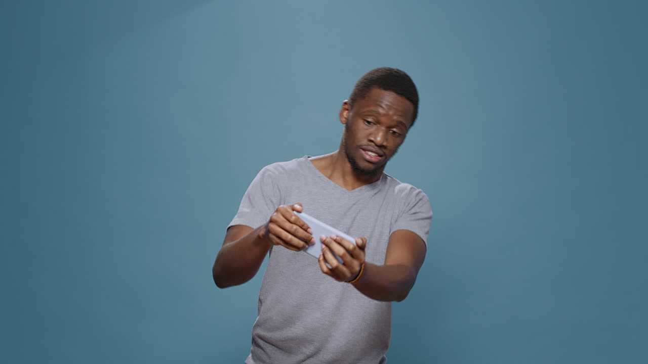 Modern person playing videogames online on smartphone