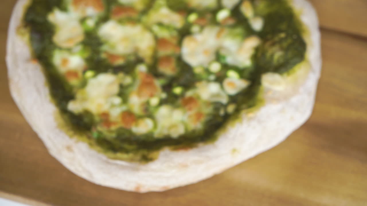 흐릿한 배경에서 온 가족이 슬라이스하고 즐길 수 있는 사워도우 크러스트가 있는 맛있는 홈메이드 이탈리아 피자의 초점에 이르기까지 슬로우 모션 팬