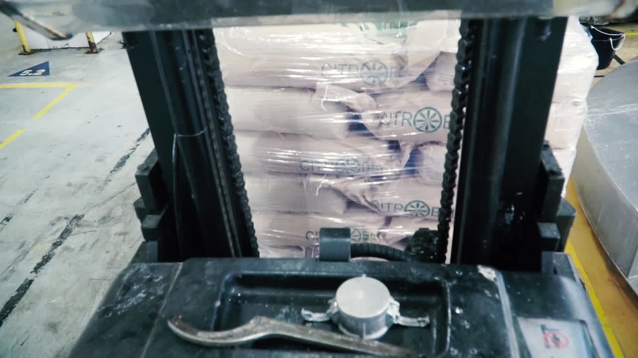 carretilla elevadora cargando paletas de bolsas en el almacén