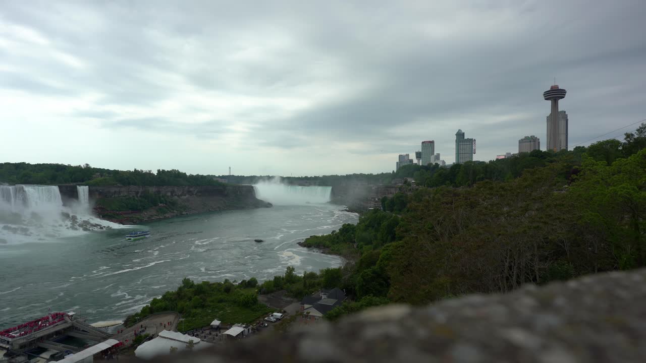 Panoramiczny widok Wodospadów Niagara, woda spływająca po wodospadzie tworząca parę, w ponury dzień.