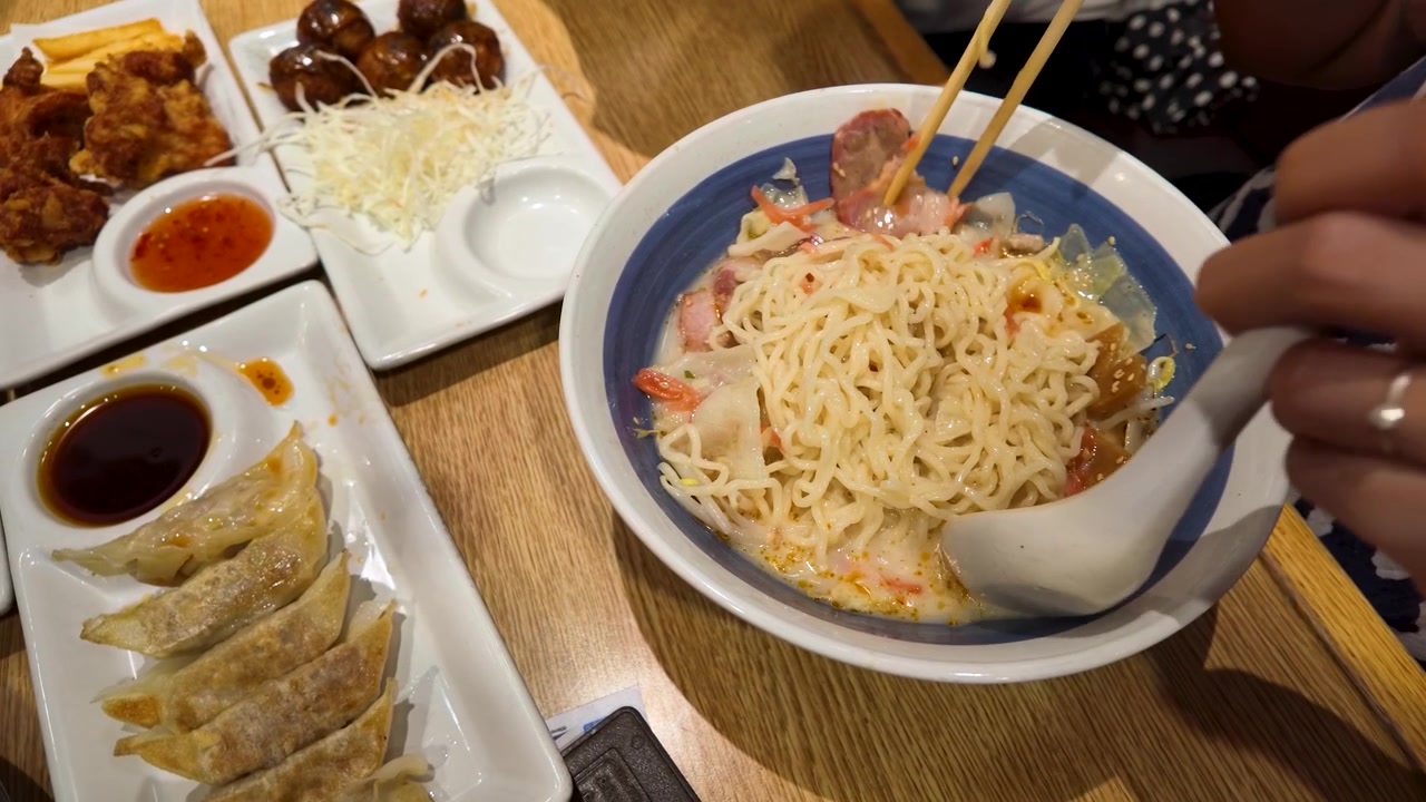 Orang Makan Mi Ramen dengan Sumpit dan Sendok di Restoran