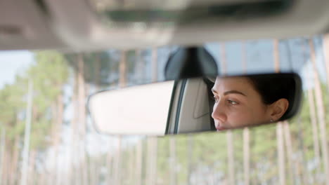 woman adjusting rear mirror