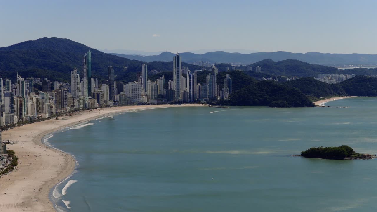 Distant aerial view of high-rise buildings rising above calm coastal beach of Balneário Camboriú, Santa Catarina, Brazil