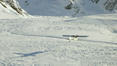 airplane flies low over deep snow covered crevasse