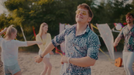 young carefree man wearing sunglasses grooving against friends
