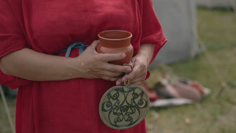 medieval woman with pottery cup and ornament