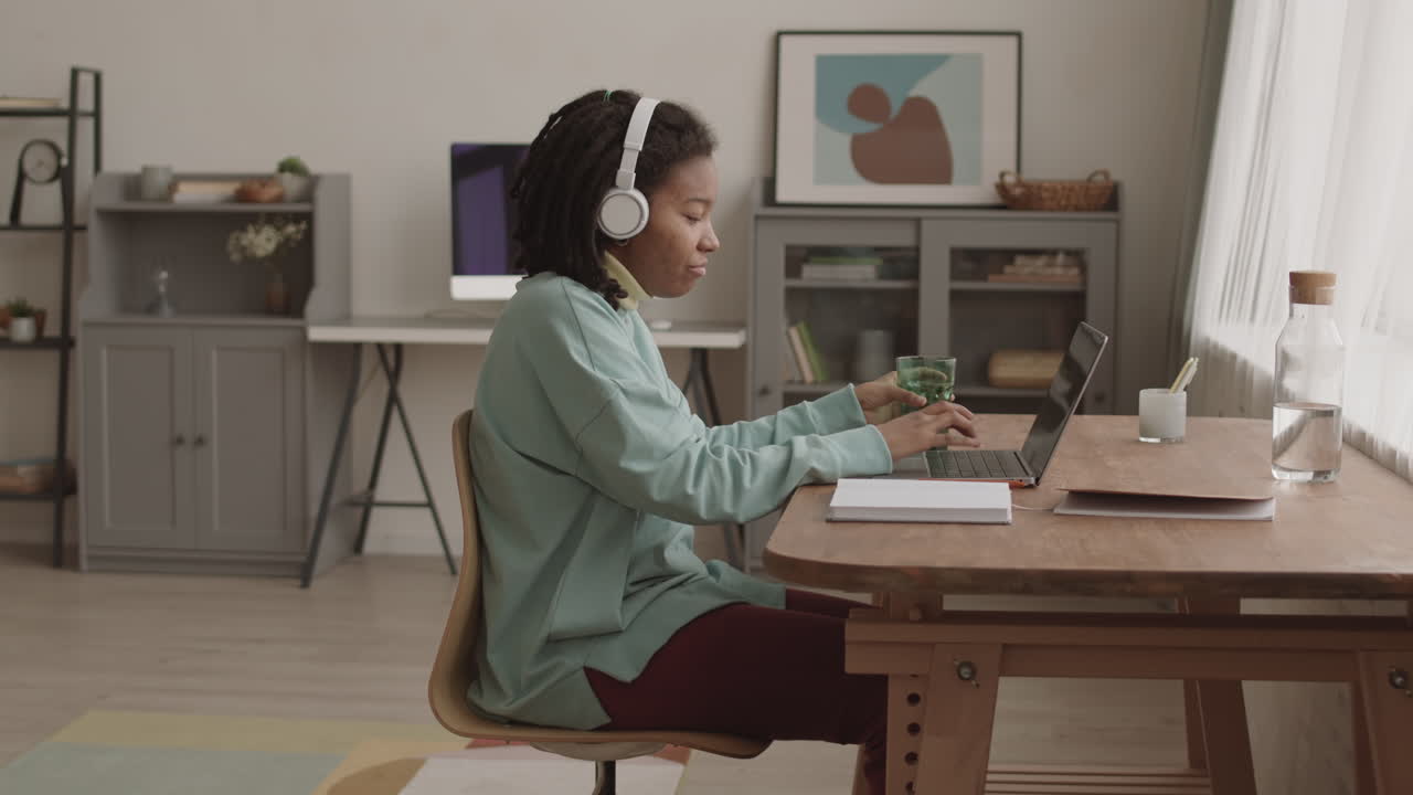 African woman Working and Listening to Music through Headphones