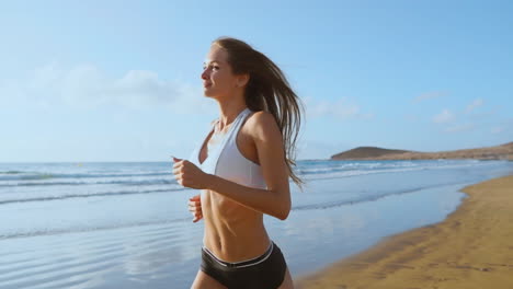 Beautiful-woman-in-sports-shorts-and-t-shirt-running-on-the-beach-with-white-sand-and-blue-ocean-water-on-the-island-in-SLOW-MOTION-STEADICAM.-Waves-and-sand-hills-on-the-back-won
