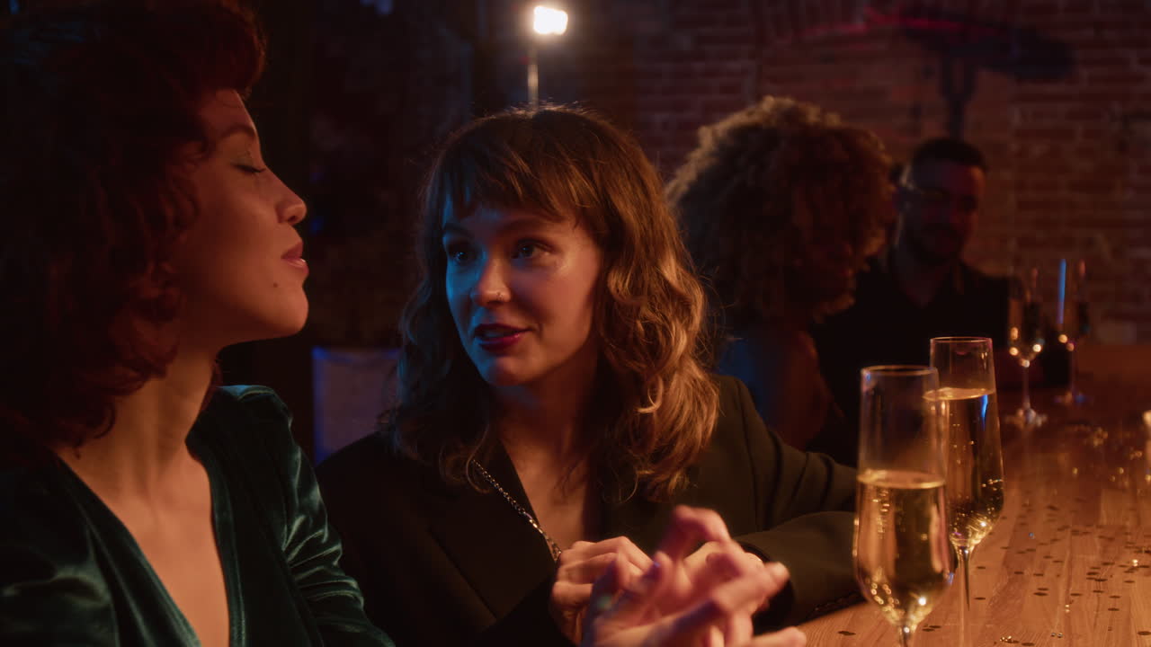 Two women celebrating with champagne at a bar
