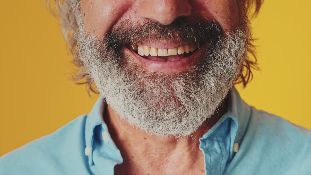 Uomo maturo felice con barba grigia sorridente