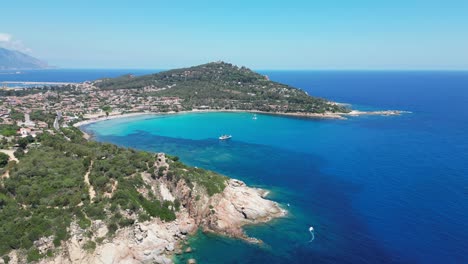 arbatax cove with turquoise blue sea and boat in sardinia, italy - aerial 4k