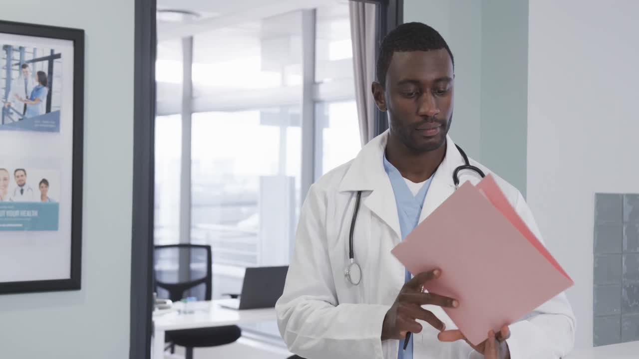 Portrait of happy african american male doctor in hospital, slow motion