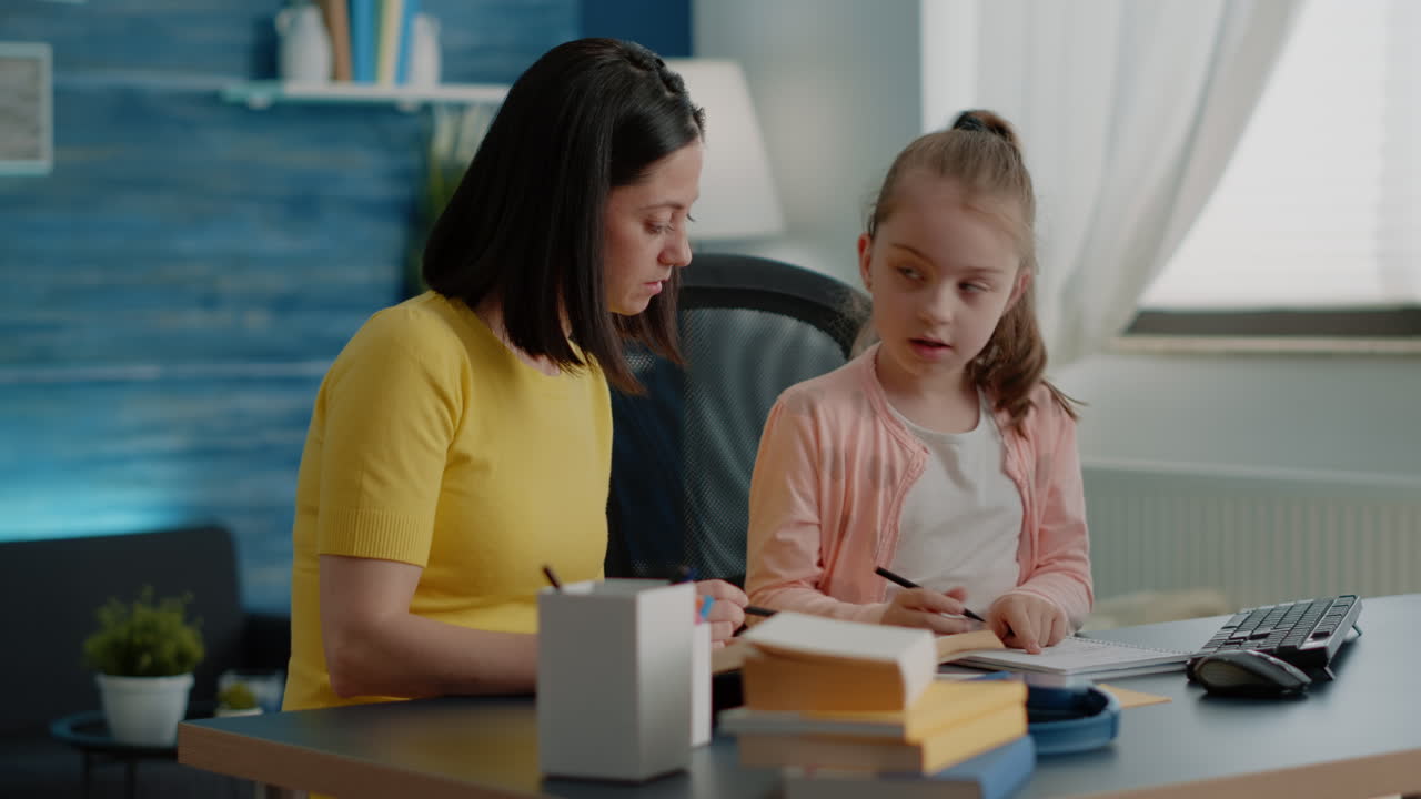 Alunno e madre che fanno i compiti insieme ai libri