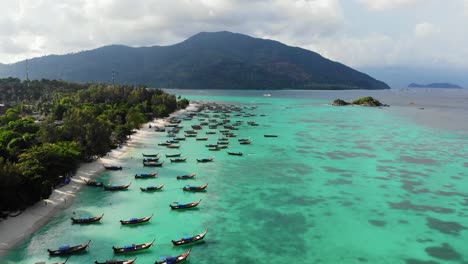 traditional thai long tailed boats on blue water of tropical island