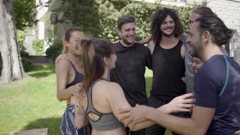 grupo de yoga feliz abrazando al aire libre