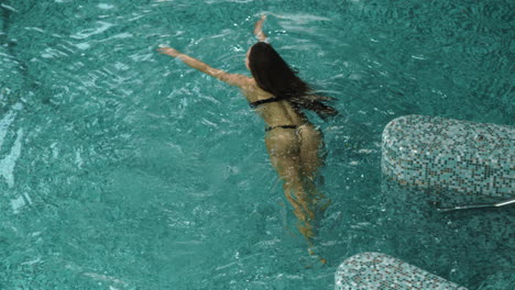 pretty girl swimming in pool in spa