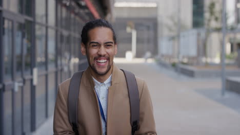 Retrato-Feliz-Joven-Empresario-Hispano-Riéndose-Disfrutando-De-La-Diversión-Usando-Un-Teléfono-Inteligente-En-La-Ciudad-Navegando-Mensajes-En-Línea-Enviando-Mensajes-De-Texto-En-Un-Teléfono-Móvil-En-Cámara-Lenta-Viajero-Urbano