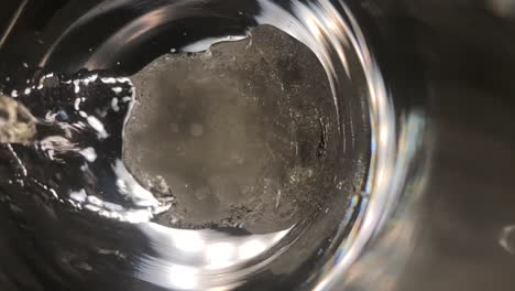 slow motion and extreme close up shot of a glass of champagne being filled up with focus on the foam and bubbles