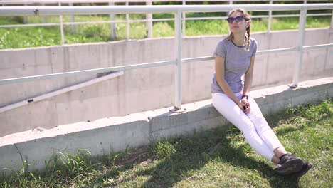 portrait of an attractive smiling caucasian woman in a park with glasses