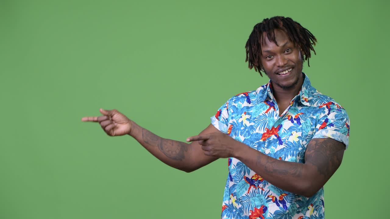 Young handsome African tourist man showing something