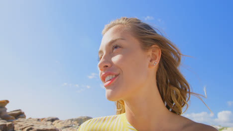 front view of young caucasian woman standing on the beach 4k