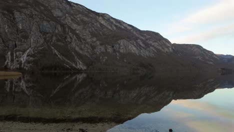 caminando por la orilla del lago bohinj con los increíbles alpes rocosos eslovenos sin nieve en el fondo