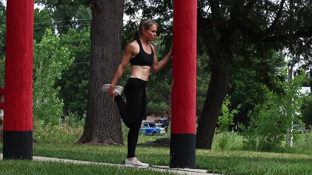 A woman stretches before her run. Limber and lengthen muscles